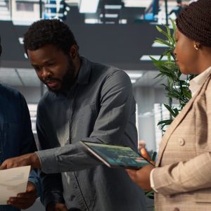 Professional team analyzing archived data on a financial file during meeting, collaborating on enterprise solutions and solving tasks to improve performance for long term growth. Camera A.